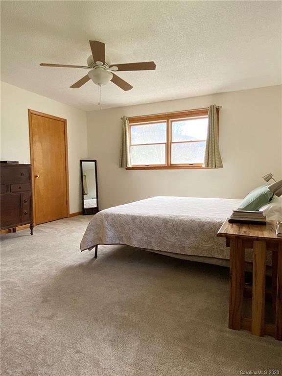 27 Morgan Branch Road Leicester, NC 28748 - Photo 18 of 39 a spacious bedroom with a bed and ceiling fan