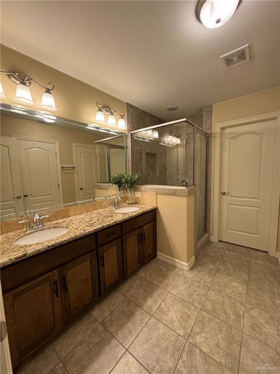 4608 Robin Avenue McAllen, TX 78504 - Photo 8 of 12 Bathroom featuring a dual vanity with granite-finish countertops, undermount sinks, and wood-finish cabinetry