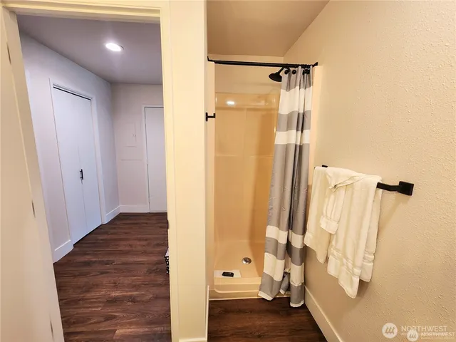 a view of a hallway with wooden floor and staircase