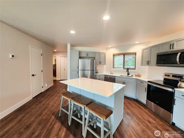 a large kitchen with sink a microwave a stove and refrigerator