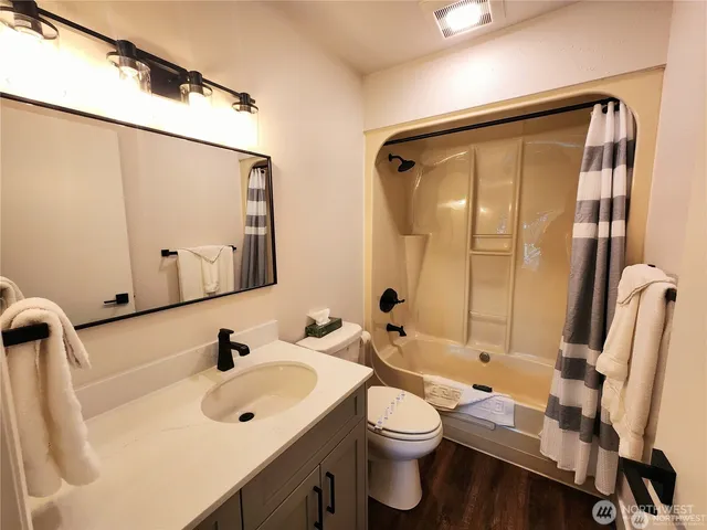 a bathroom with a sink mirror vanity and toilet
