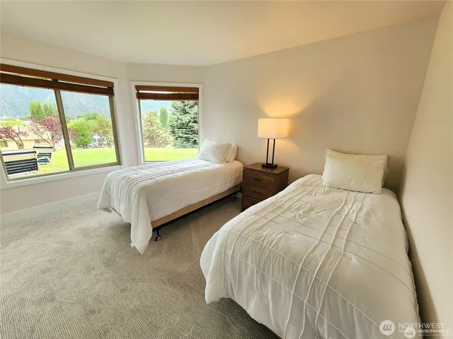 a bedroom with two beds and a large window