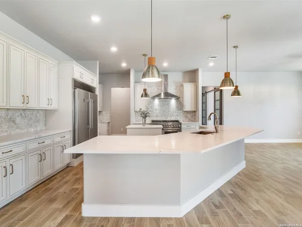 a kitchen with a sink stove and wooden floor