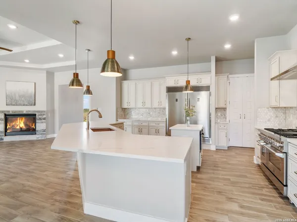 a kitchen with granite countertop a stove and a white cabinets