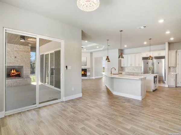 wooden floor in an empty room with a fireplace and a window