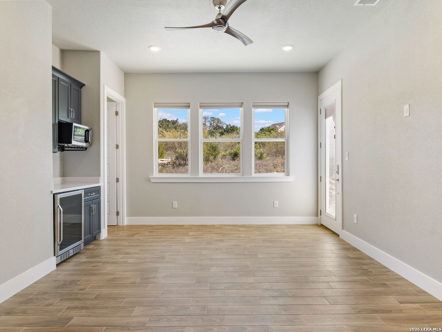 250 Private Road 2775 Mico, TX 78056 - Photo 27 of 57 wooden floor in an empty room with a fireplace and a window