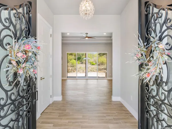 a view of an empty room with wooden floor and a fireplace