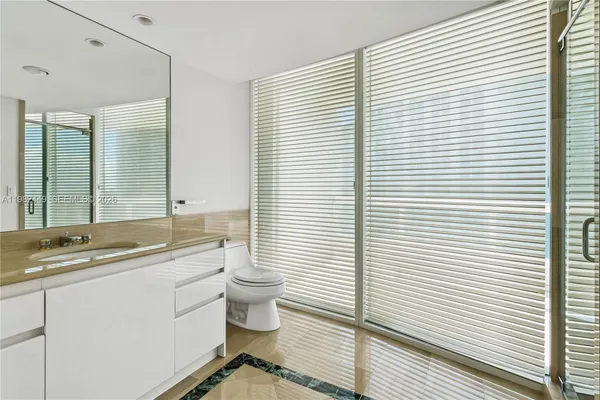 a bathroom with a toilet a sink and mirror
