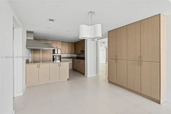 a kitchen with stainless steel appliances granite countertop a refrigerator a oven a sink with a dining table and chairs