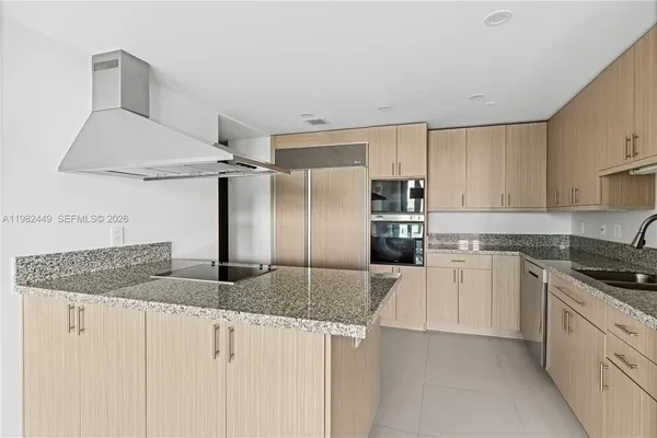 a kitchen with stainless steel appliances granite countertop a sink a stove and refrigerator