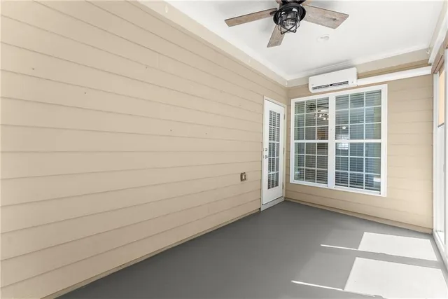 an empty room with a ceiling fan and windows