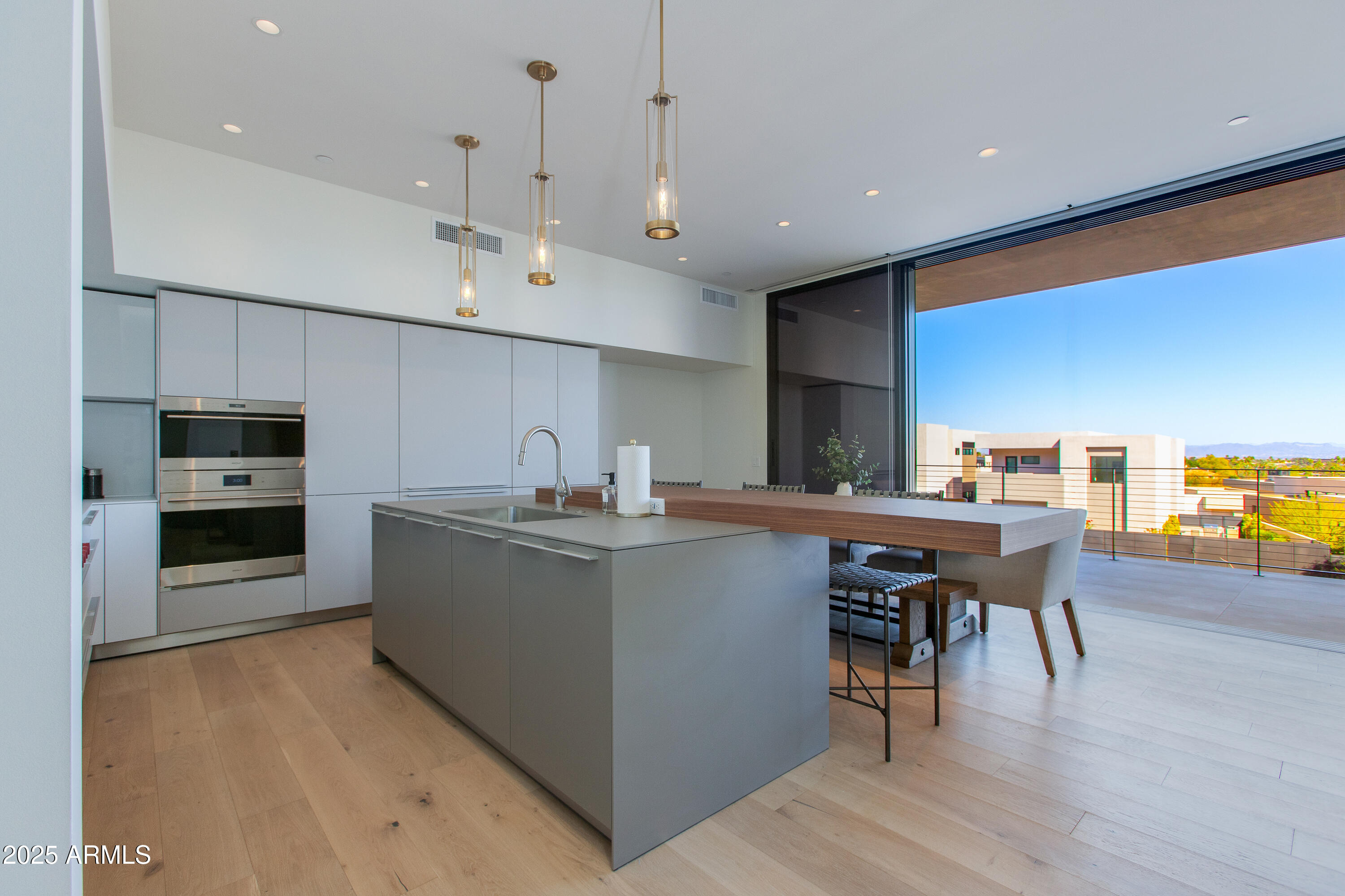 5000 North Camelback Ridge Drive, Unit 206 Scottsdale, AZ 85251 - Photo 21 of 62 a kitchen with stainless steel appliances a stove a sink a oven a dining table and chairs with wooden floor