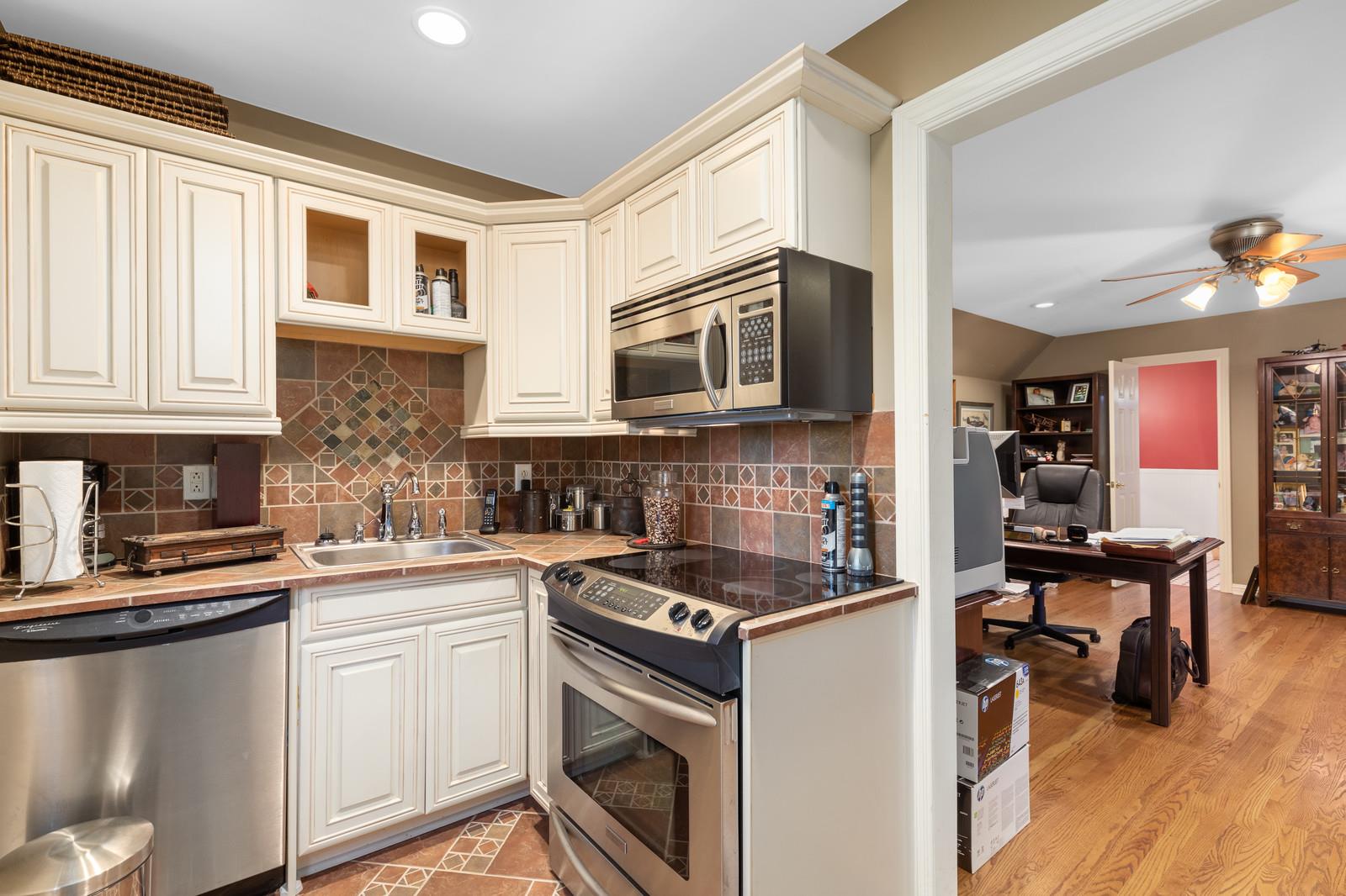 4304 Clarence Murphy Road Springfield, TN 37172 - Photo 27 of 30 a kitchen with stainless steel appliances granite countertop a stove top oven a sink dishwasher and white cabinets with wooden floor