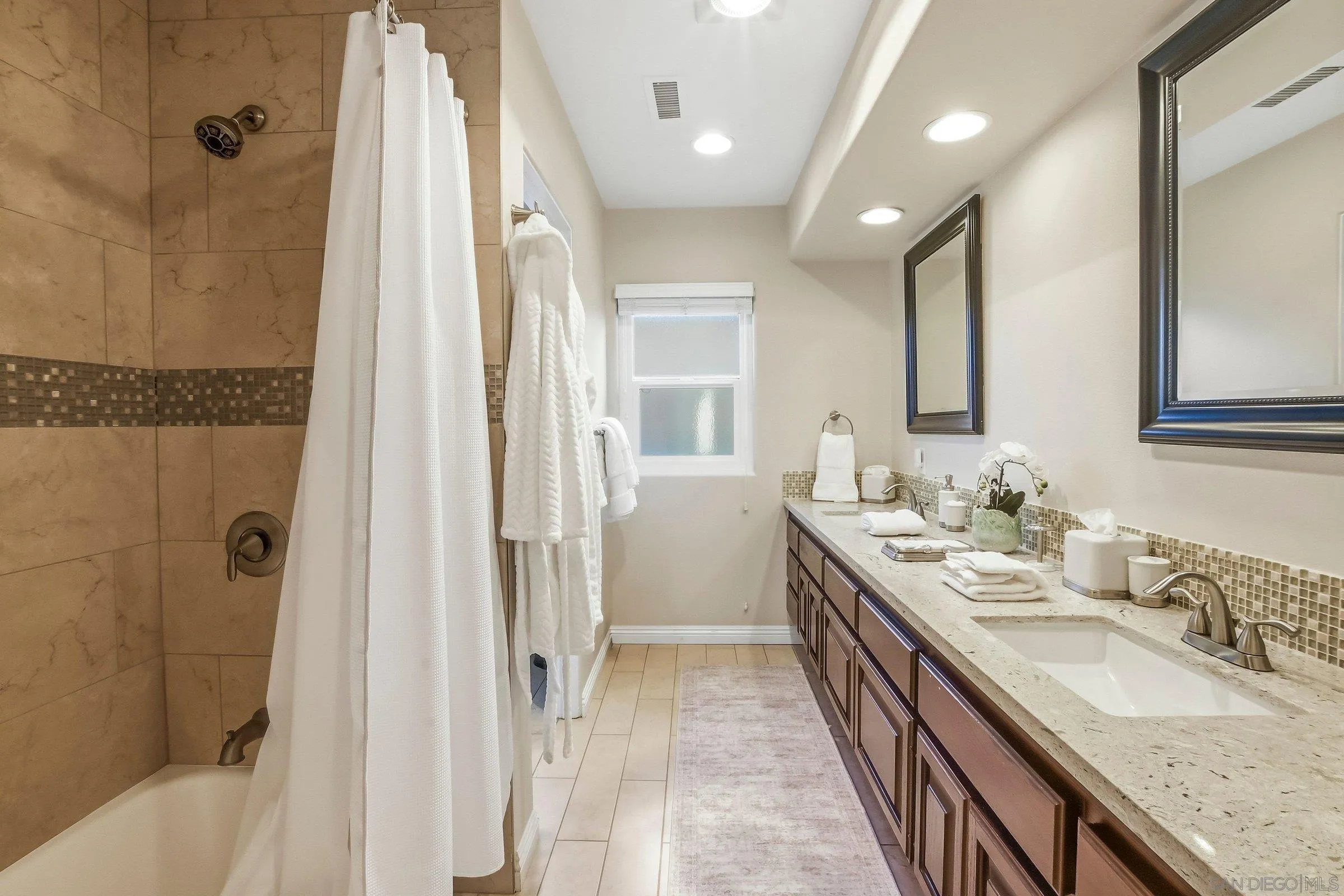 52 Spinnaker Way Coronado, CA 92118 - Photo 28 of 45 a bathroom with a granite countertop double vanity sink a mirror and a shower