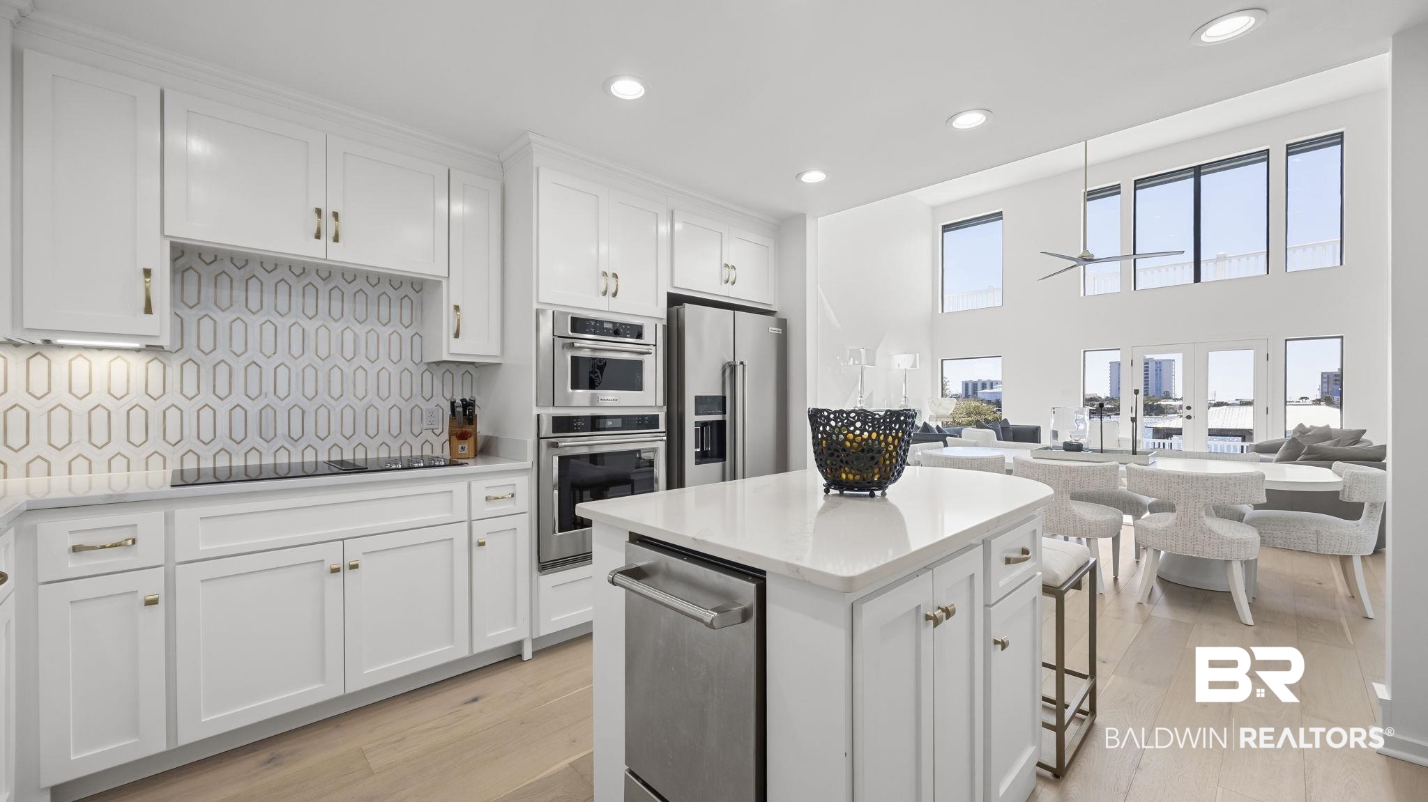 30194 River Road Orange Beach, AL 36561 - Photo 45 of 45 Kitchen featuring white cabinetry, open floor plan, recessed lighting, light stone countertops, and a high ceiling