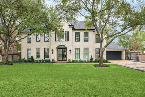 a front view of a house with a yard and trees