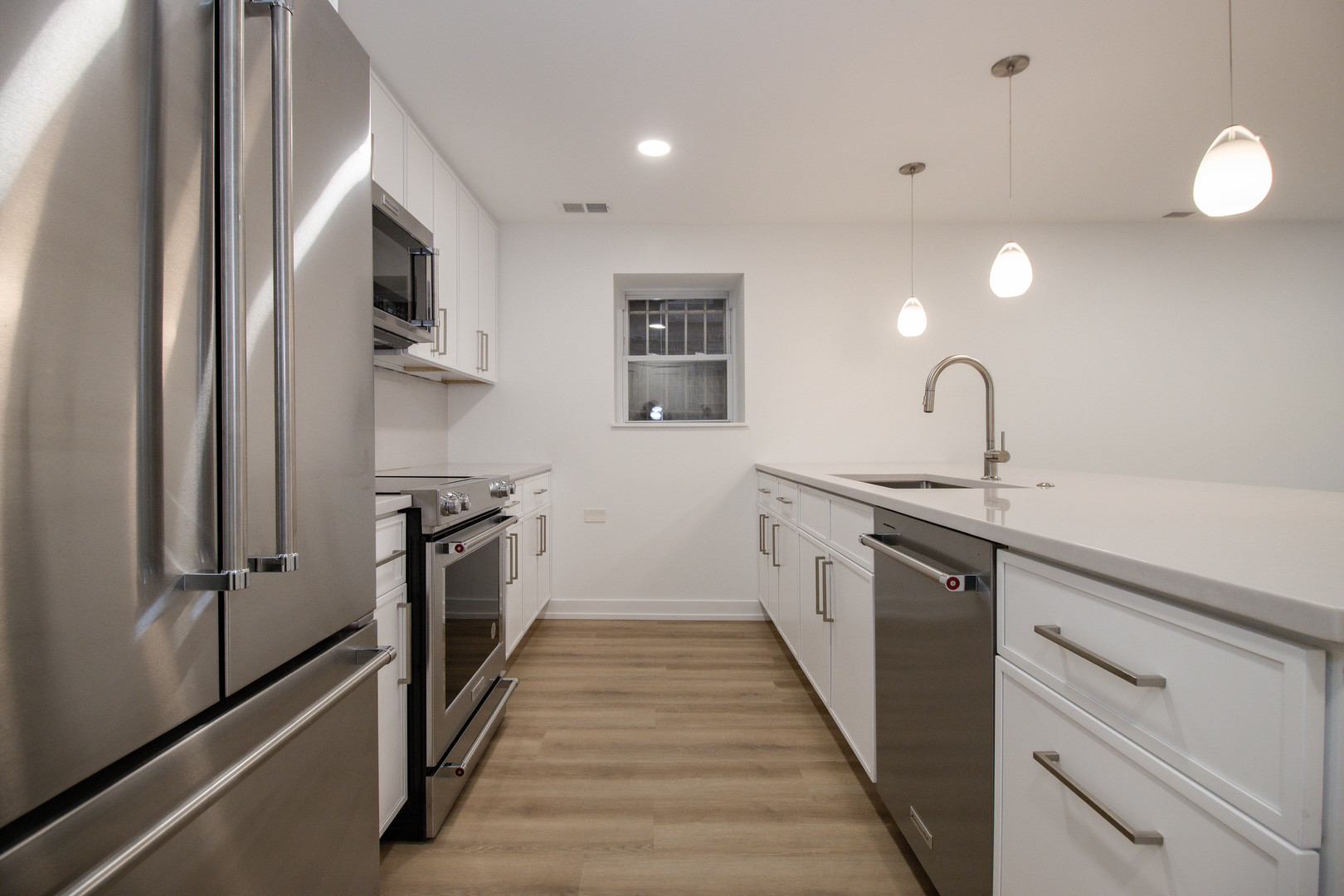 1139 North Winchester Avenue, Unit G Chicago, IL 60622 - Photo 7 of 22 a kitchen with white cabinets and stainless steel appliances