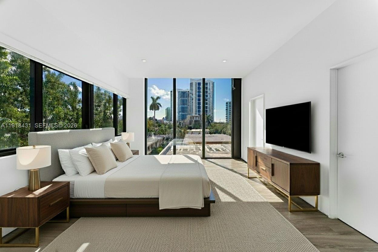 1525 Bay Road, Unit 1525 Miami Beach, FL 33139 - Photo 15 of 37 a bedroom with bed and large flat screen tv