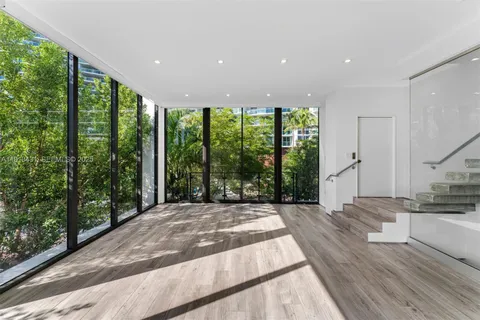 a spacious bedroom with a large window and a balcony