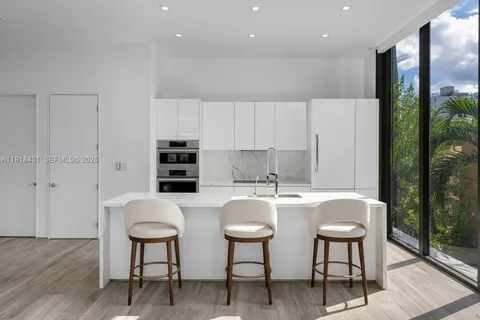 a kitchen with stainless steel appliances a table and chairs in it