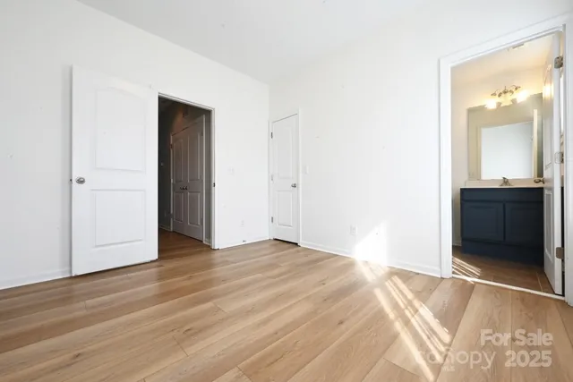an empty room with wooden floor and cabinet