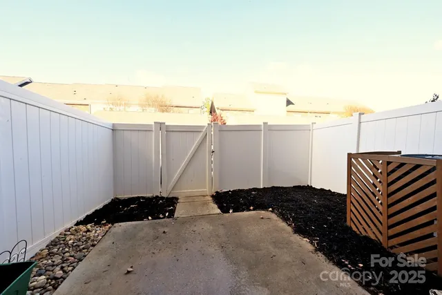 a view of a backyard with wooden fence