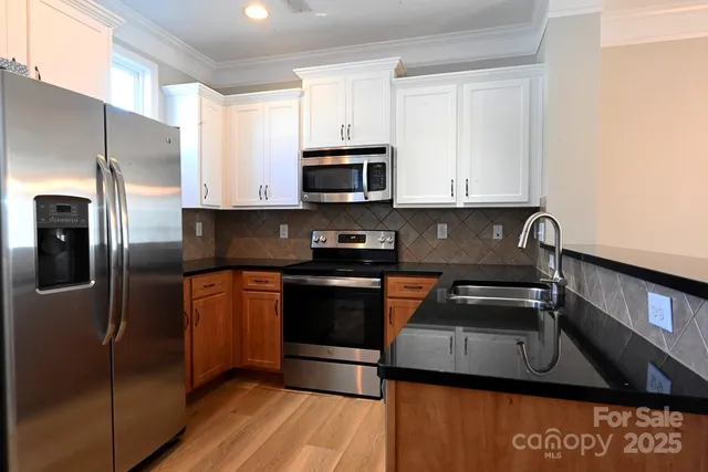 a kitchen with stainless steel appliances granite countertop a stove a refrigerator and a sink