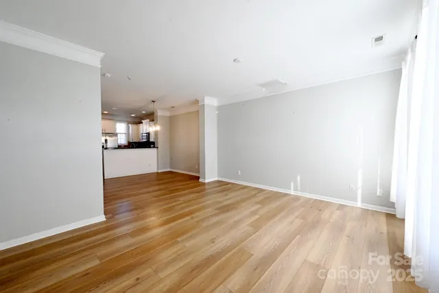 a view of empty room with wooden floor
