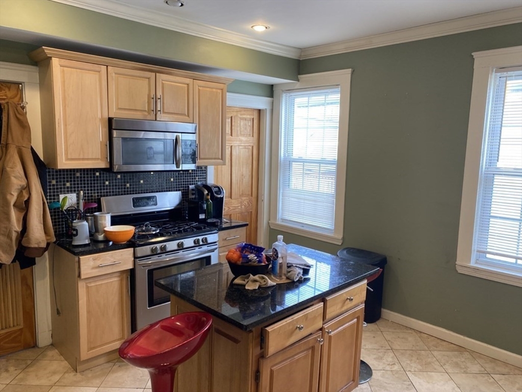 19 Pleasant Street, Unit 2 Boston, MA 02125 - Photo 1 of 11 a kitchen with stainless steel appliances a stove a sink dishwasher and a microwave