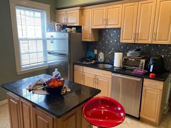 a kitchen with stainless steel appliances a sink a microwave a refrigerator and cabinets