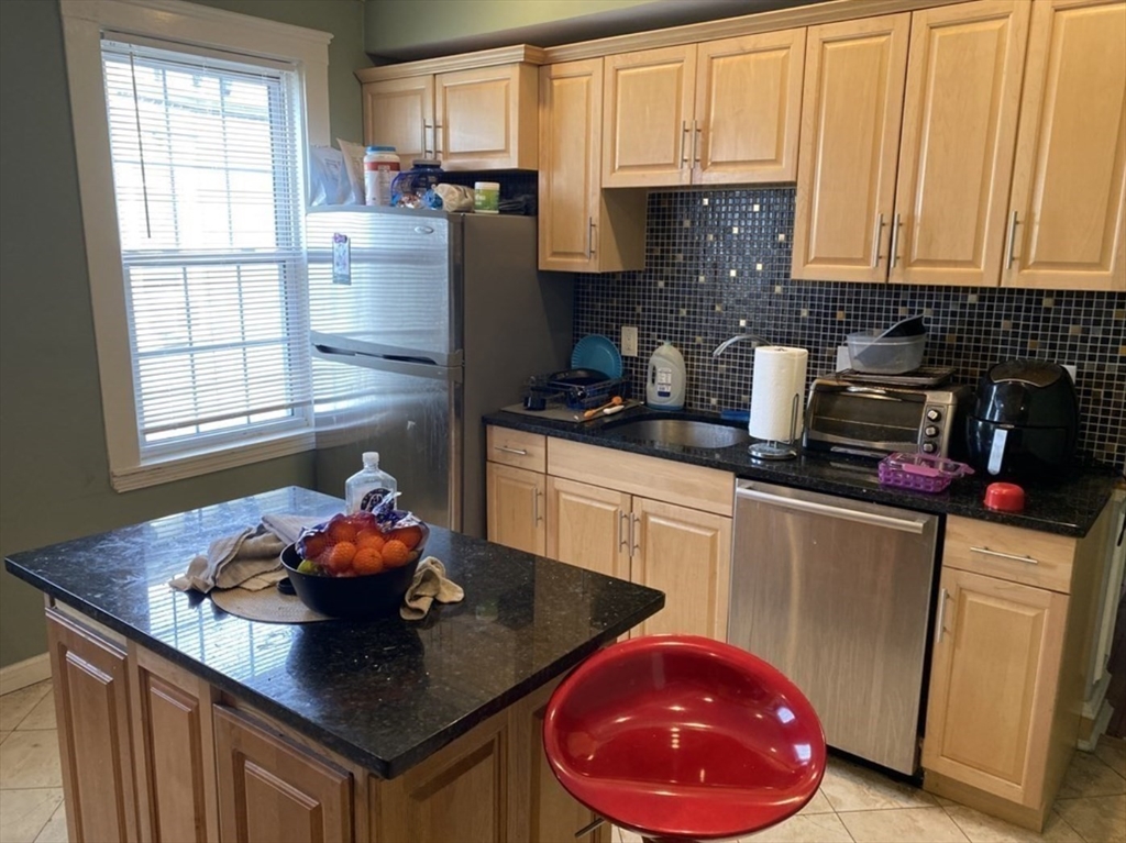 19 Pleasant Street, Unit 2 Boston, MA 02125 - Photo 2 of 11 a kitchen with stainless steel appliances a sink a microwave a refrigerator and cabinets
