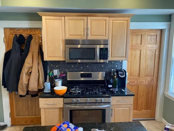 a kitchen with stainless steel appliances kitchen island granite countertop a stove a sink and a microwave