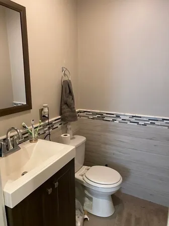 a bathroom with a toilet sink and mirror