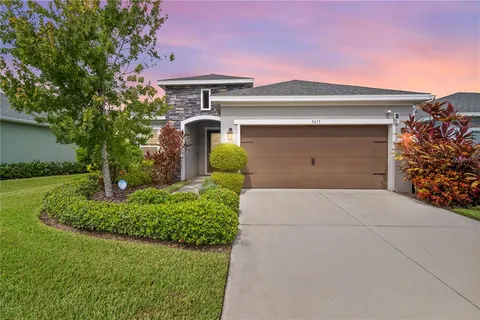 a front view of a house with a yard and garage