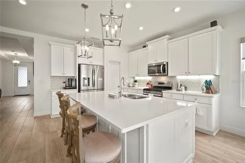 a living room with stainless steel appliances kitchen island granite countertop a couch dining table and chairs