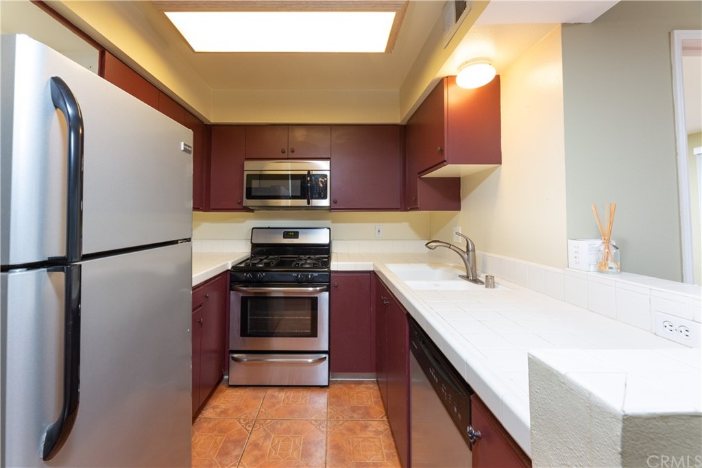 801 Pine Avenue, Unit 301 Long Beach, CA 90813 - Photo 10 of 18 a kitchen with kitchen island a sink stainless steel appliances and cabinets