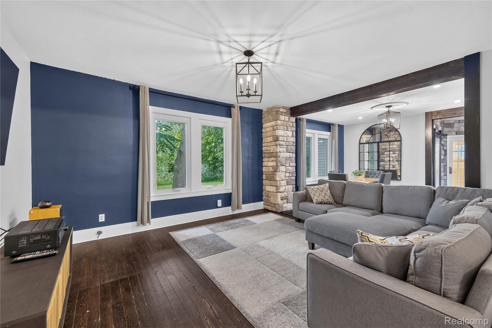 4860 Blue Bush Road Monroe, MI 48162 - Photo 19 of 59 Spacious living area featuring dark wood-finish flooring, a prominent stone column, and exposed wood ceiling beams