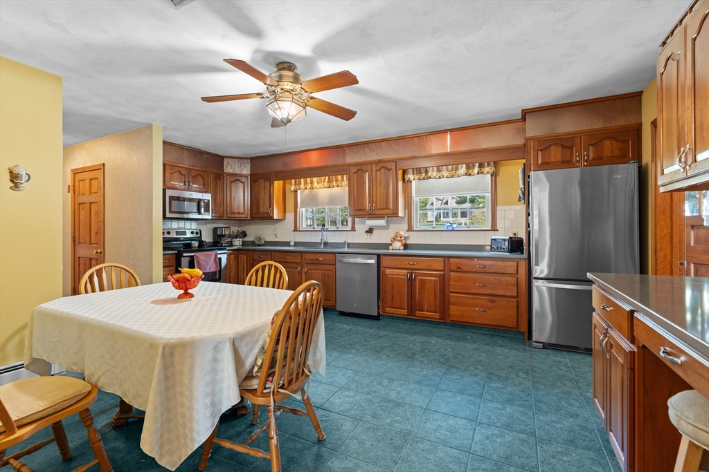 36 High Street Freetown, MA 02702 - Photo 19 of 42 a kitchen with a refrigerator a sink a stove a dining table and chairs
