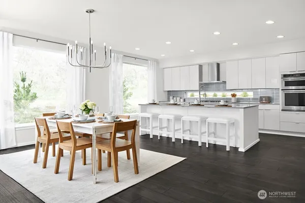 a large white kitchen with a sink and dishwasher with a large mirror next to a window