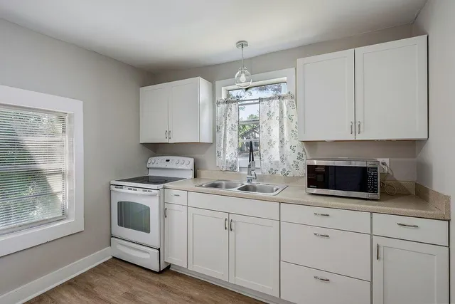 a kitchen with white cabinets and white appliances