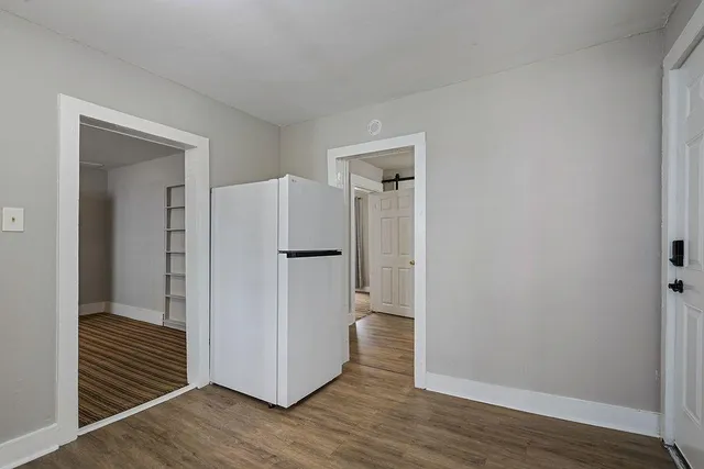 a view of a hallway with wooden floor and closet area