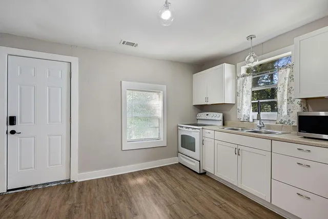 a kitchen with a sink cabinets appliances and a window