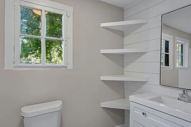 a bathroom with a sink mirror vanity and toilet