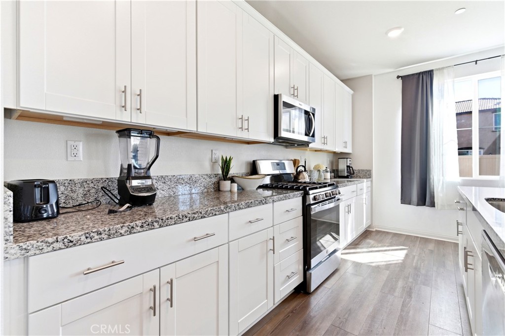 15594 Raptor Road Moreno Valley, CA 92551 - Photo 17 of 53 a kitchen with appliances cabinets and a counter top space