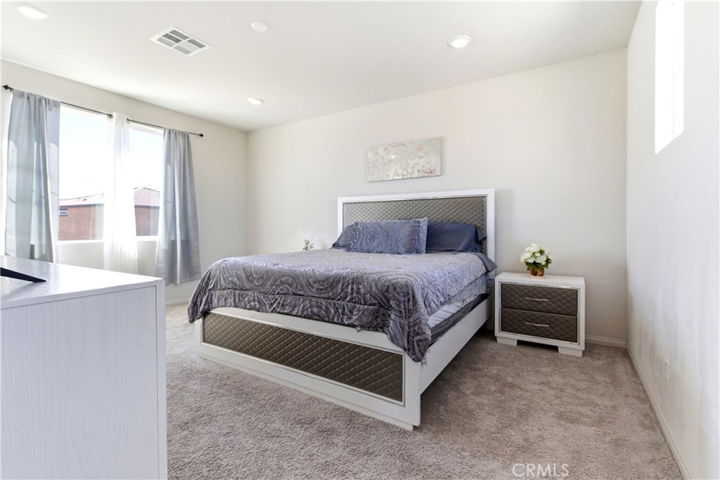 15594 Raptor Road Moreno Valley, CA 92551 - Photo 36 of 53 a bedroom with a bed and a cabinets