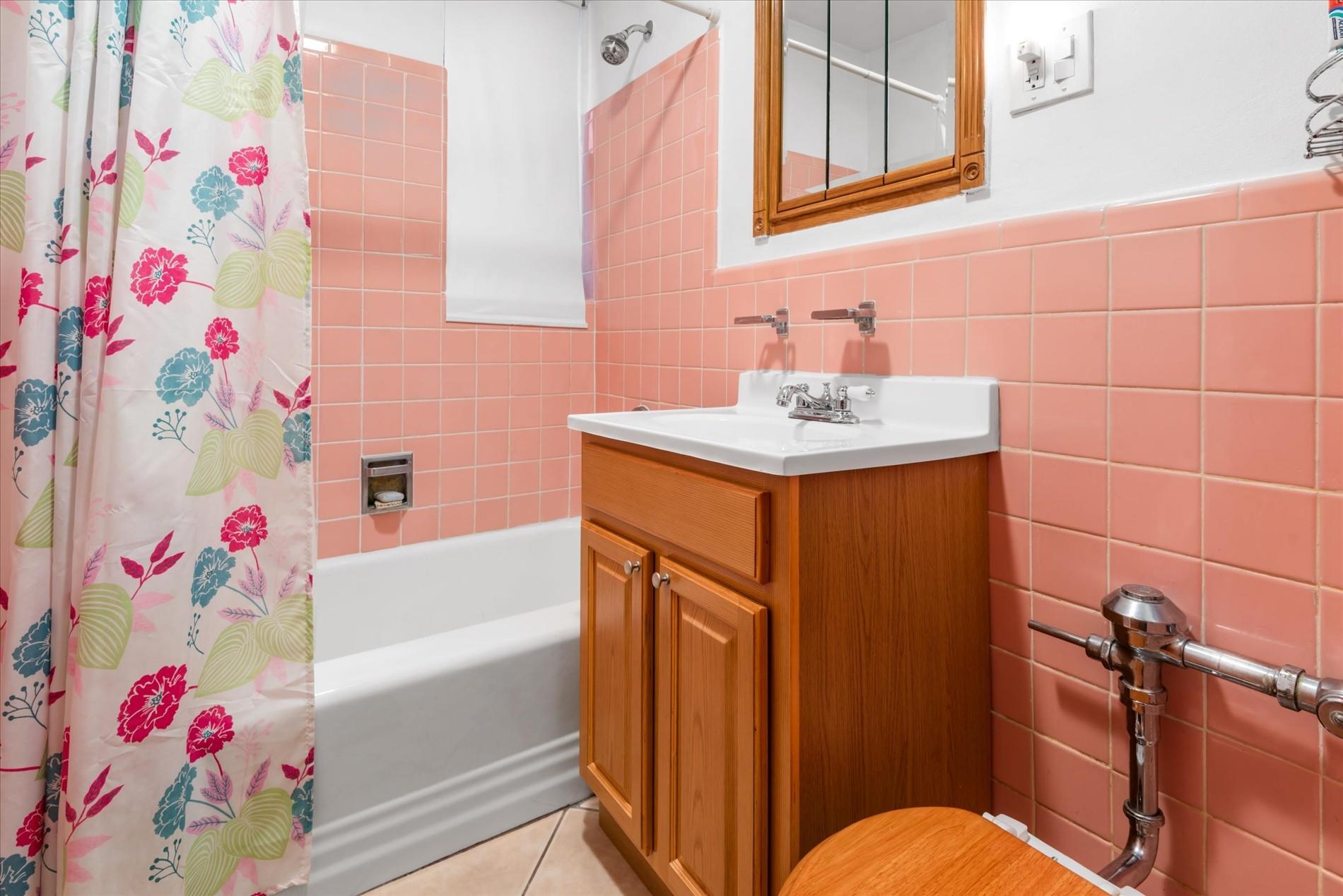 83-75 Woodhaven Boulevard, Unit 1E Queens, NY 11421 - Photo 11 of 15 a bathroom with a sink toilet vanity and bathtub