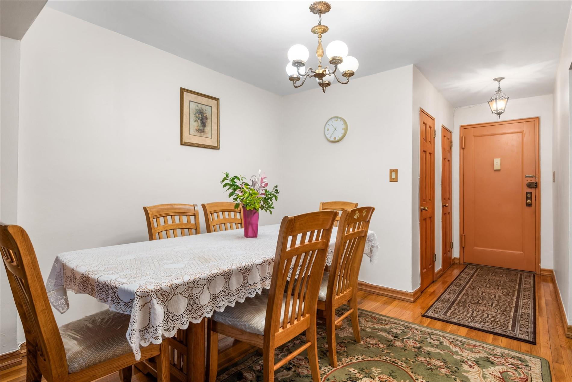 83-75 Woodhaven Boulevard, Unit 1E Queens, NY 11421 - Photo 5 of 15 a view of a dining room with furniture and chandelier