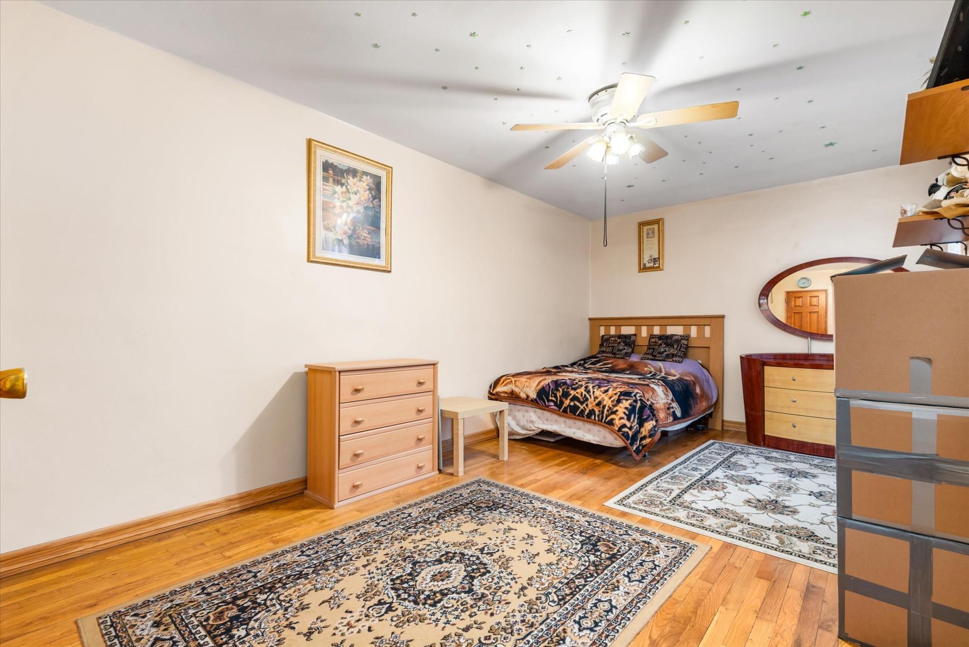 83-75 Woodhaven Boulevard, Unit 1E Queens, NY 11421 - Photo 8 of 15 a bedroom with a bed and a chandelier