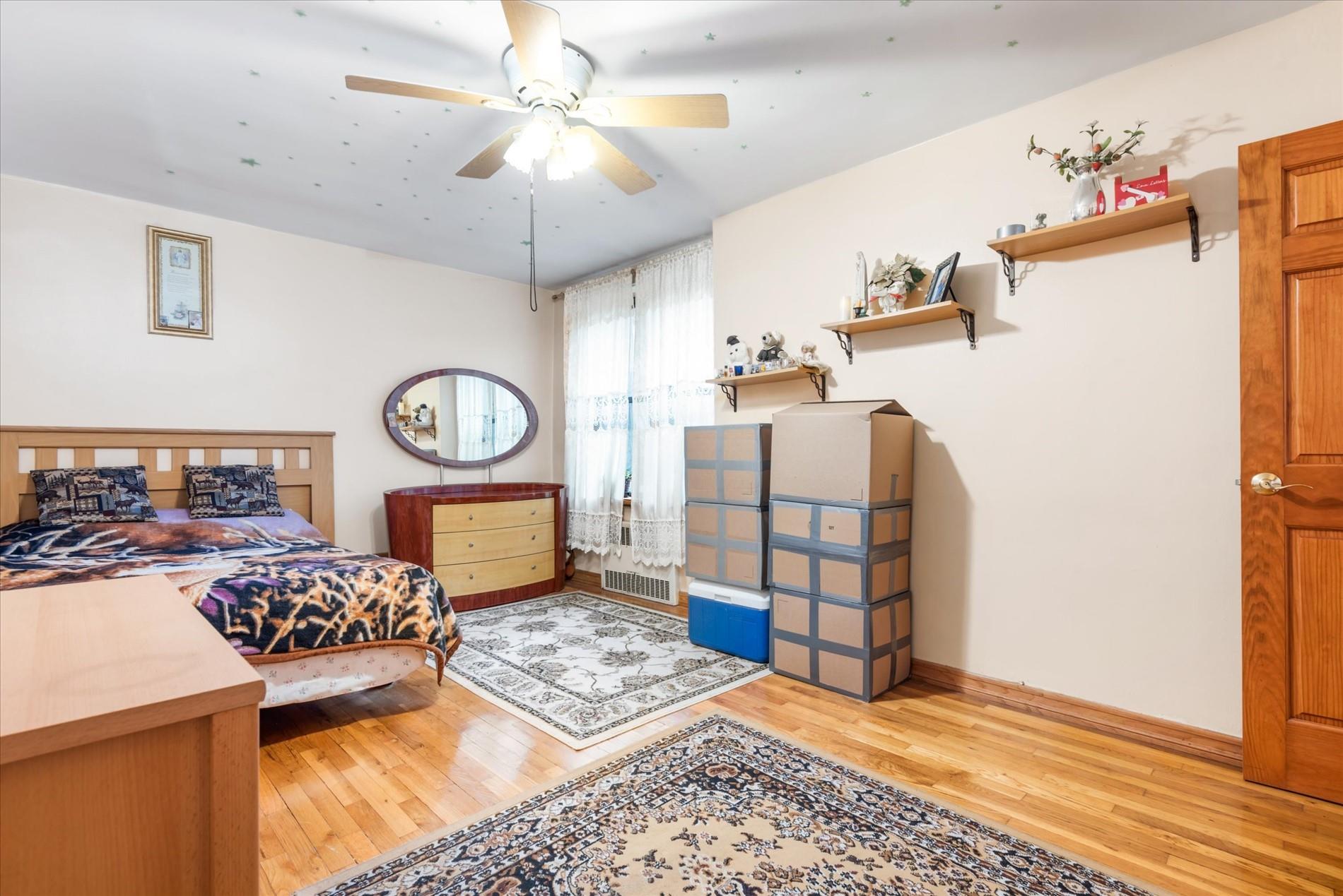83-75 Woodhaven Boulevard, Unit 1E Queens, NY 11421 - Photo 9 of 15 a bedroom with furniture and a dresser