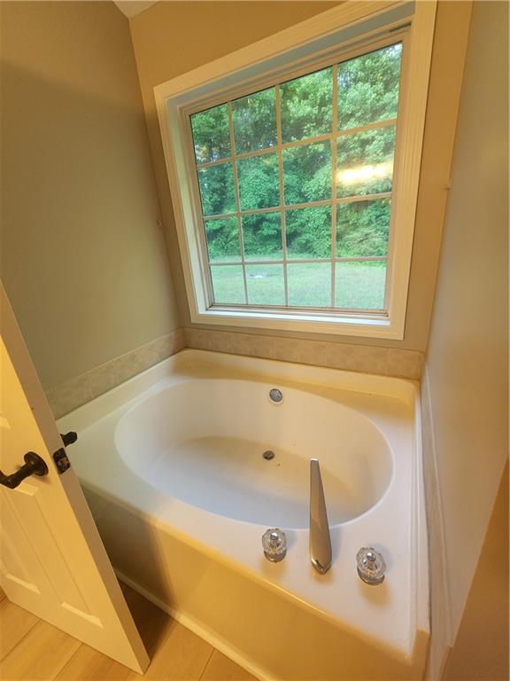 435 Butler Bridge Circle Covington, GA 30016 - Photo 7 of 25 a bath tub sitting next to a window